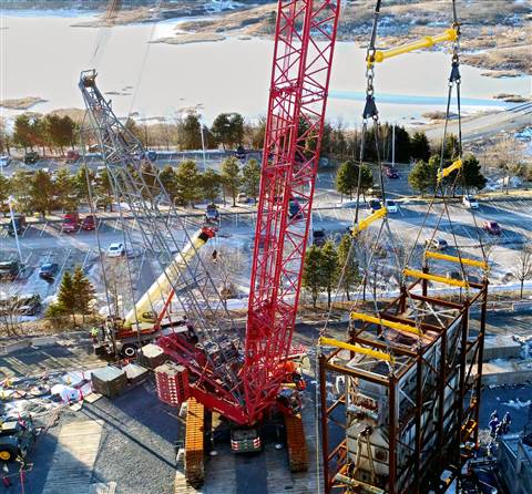 Spectacular aerial view of a red Irving Equipment crawler crane lifting a pipe rack in a refinery using a complex arrangement of multiple Modulift beams